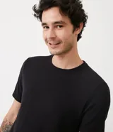 Remera de hombre color beige claro, de corte slim, con cuello redondo y mangas cortas. Tejido acanalado sin estampa.