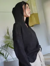 Sweater negro de tejido de punto con capucha y escote en V.