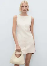 Vestido corto de corte entallado, confeccionado en tejido mezcla de lino y viscosa. Presenta cuello barco, cierre frontal con botones y dos bolsillos laterales de ribete. Incluye forro interior.