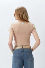 Top corto negro ajustado al cuerpo, de manga corta y cuello redondo.