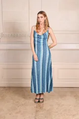 Vestido midi con estampado de ondas verticales en tonos fucsia, verde y plateado. Tiene breteles finos, escote drapeado y espalda baja.