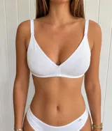 Corpiño triangular de lycra sin aro, con breteles ajustables y desmontables, cierre posterior con broche y detalle de pequeña flor en el centro del escote.