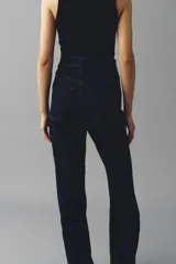 Jean wide leg de tiro alto en denim azul oscuro con costuras en tono contraste, trabillas para cinto y cierre frontal con botón metálico.