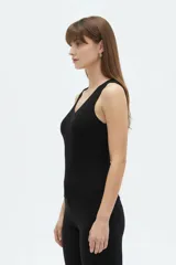 Musculosa de algodón color blanco, con tirantes anchos, escote en V cruzado y diseño asimétrico de canalé.