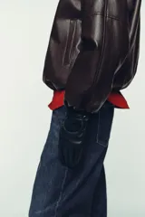 Guantes cortos de mujer combinados en cuero sintético y tejido de punto a tono, con detalle de tira con botones a presión en el dorso.