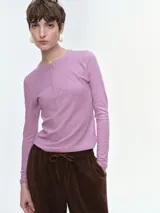 Remera de manga larga confeccionada en tejido acanalado, con escote redondo y cierre frontal con botones. Presenta un ajuste entallado al cuerpo.