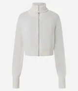 Campera cropped de tricot color blanco off-white, confeccionada en algodón con textura acanalada. Presenta cuello amplio con cierre metálico frontal, mangas largas con puños acanalados y cintura marcada con banda ancha.