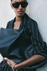 Bolso shopper de diseño slouchy, color negro, con asas largas y cierre magnético oculto. Incluye un estuche extraíble con cierre.