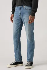 Jean de corte slim fit, color celeste, con cierre de cremallera y botón metálico. Presenta un diseño clásico de cinco bolsillos con costuras reforzadas.