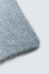 Bufanda de punto tejida en hilatura con mezcla de fibra de alpaca, de textura suave y diseño rectangular.