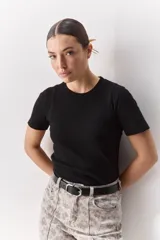 Remera blanca de manga corta y cuello redondo, con calce ajustado al cuerpo y diseño liso y minimalista.