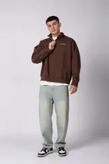 Buzo de cuello alto con cierre frontal parcial, manga larga y diseño holgado. Presenta un pequeño logo bordado en el pecho.