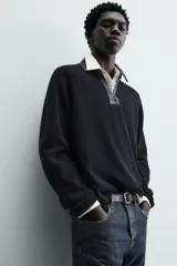 Polo de punto color azul marino, de calce relajado y manga larga. Presenta un cuello solapa de tejido denim en contraste con una abertura frontal en forma de V.