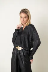 Blusa italiana laminada color dorado, de corte cruzado con elástico en la cintura y mangas largas.