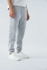 Pantalón de jogging gris melange, corte recto, con bolsillos laterales y logo en grifa de goma.