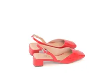 Zapatos slingback de charol color rojo, con diseño de punta cuadrada, escote en V y taco bajo cuadrado. Cuentan con tira trasera ajustable mediante hebilla.