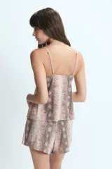 Conjunto de pijama compuesto por una musculosa con breteles finos y detalle de encaje en el escote, y un short corto. Presenta un estampado animal print de serpiente en tonos tierra.
