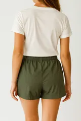 Short negro de poliéster, de calce holgado y tiro medio, con cintura elástica y cordón ajustable.