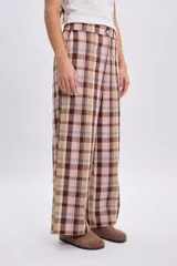 Pantalón de corte ancho a cuadros en tonos de verde, marrón y rosado.