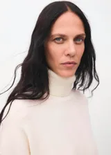 Vestido corto de punto con cuello vuelto y manga larga, de diseño recto y estilo minimalista.