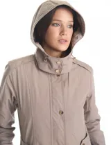 Gabardina impermeable de alta densidad color beige, con capucha desmontable, cierre metálico oculto bajo cartera con botones a presión dorados y forro interno desmontable.