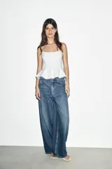 Top negro ajustado al cuerpo con escote recto y tirantes finos. Presenta un bajo con corte peplum.