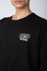 Remera blanca de corte oversize con mangas cortas y cuello redondo. Estampado pequeño en el frente con letras verdes.