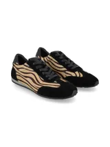 Championes urbanos con diseño combinado en gamuza negra y paneles laterales de pelo sintético con estampado animal print tipo cebra. Presentan cordones negros y suela plana de goma.
