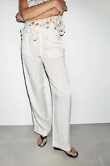 Pantalón de tiro medio con corte recto, cintura elástica con cordón ajustable, bolsillos delanteros y bolsillos de plastrón en la parte trasera.
