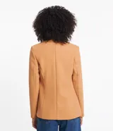 Blazer de corte sastrero en tejido polivelour color tostado. Presenta diseño cruzado con doble botonadura frontal, solapas clásicas y bolsillos laterales. De manga larga y estructura entallada.
