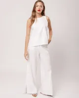 Pantalón negro de lino, tiro alto, corte palazo, con elástico en la pretina trasera, cierre delantero y broche interno. Tiene bolsillos laterales, dobladillo invisible y tajos a los costados.