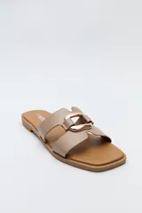 Sandalias planas de diseño abierto, color tostado, con capellada de tiras anchas y un herraje metálico circular en el centro.
