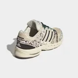 Championes Adidas Adistar Control 5 de estilo running retro, con exterior de malla transpirable en tono beige y detalles con estampado animal print tipo dálmata o vaca en tonos marrones y blancos. Cuenta con las clásicas tres tiras laterales en marrón oscuro, cordones verdes y suela amortiguada.
