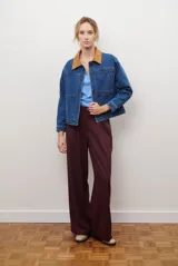 Chaqueta de jean azul con cuello de gamuza color camel, bolsillos delanteros y cierre de botones.