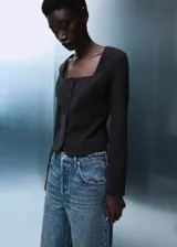 Jeans de tiro medio con diseño wide leg, confeccionados en tejido de algodón estilo tejano. Presentan un acabado con adorno de strass, cierre de botones y cinco bolsillos.