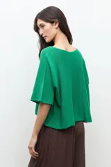 Sweater oversized de punto color verde, con escote en V y mangas cortas holgadas.