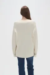 Sweater de punto con diseño de ochos, color rojo, con cuello en V y mangas largas de corte holgado.