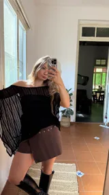 Capa de hilo negra con diseño de hombros descubiertos, mangas anchas y acampanadas, y textura de rayas verticales.