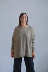 Sweater de punto con acabado brillante en tono verde oliva, de corte holgado y diseño con costuras verticales decorativas. Presenta cuello redondo y mangas largas con puños ajustados.