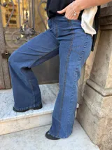 Pantalón de jean estilo wide leg con diseño de paneles y costuras visibles en contraste. Presenta un corte amplio y tiro alto, confeccionado en denim con elasticidad.
