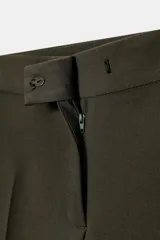 Pantalón de vestir color marrón oscuro, tiro alto, corte recto o ligeramente cropped, con pinzas frontales y bolsillos laterales.