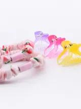 Set de accesorios para el cabello compuesto por dos colitas tipo scrunchie de tela estampada en tonos celestes y tres broches tipo pinza de acrílico translúcido en colores azul, celeste y rosado.