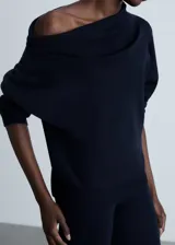 Jersey de punto con cuello asimétrico envolvente y diseño de hombros caídos. Presenta un corte recto y mangas largas con puños ajustados.