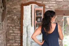 Vestido largo azul marino de lycra de algodón, con corte amplio, escote redondo al frente y escote profundo en la espalda. Tiene breteles con lazos ajustables, bolsillos y tajos laterales.