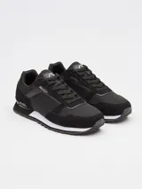 Championes urbanos Rusty modelo Nour, color negro con detalles en blanco en la entresuela. Presentan un diseño de paneles combinados en gamuza y material sintético, con cordones al tono y logo de la marca en la lengüeta y el lateral.
