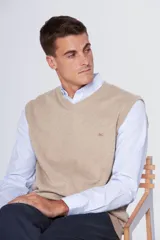 Chaleco tejido de hilo de algodón en color beige, con escote en V y pequeño logo bordado en el pecho.
