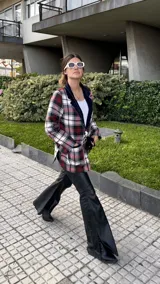 Blazer de paño de lana con estampado a cuadros en tonos rojo, blanco y negro. Tiene solapa en pana azul marino y corte recto.