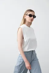 Remera sin mangas blanca con hombros marcados y caída recta.