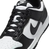 Championes Nike modelo Dunk Low Retro, en colores blanco y negro, confeccionados en cuero sintético, con diseño clásico de perfil bajo, suela de goma y cordones al tono.