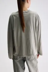 Remera de manga larga color gris verdoso, de calce relajado, con cuello redondo y mangas amplias.